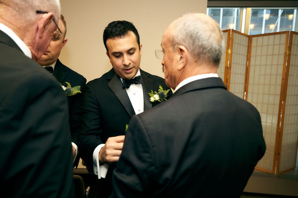 Formal gathering with people in tuxedos interacting in an indoor space. Siant peters church