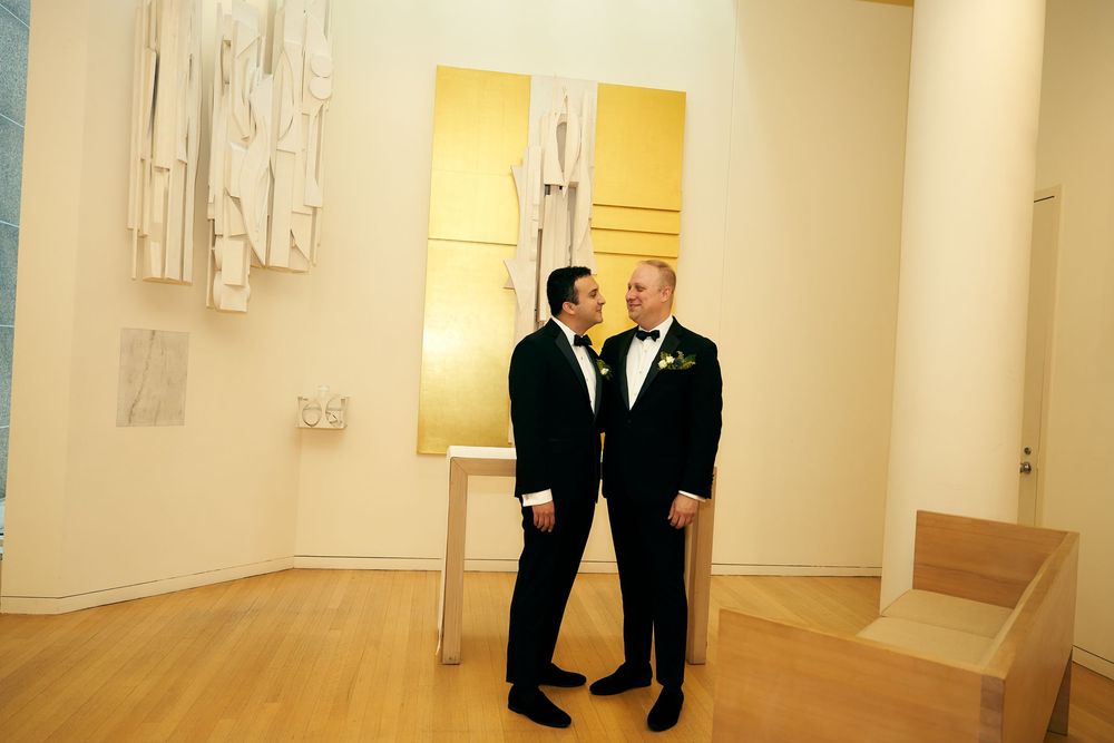 Art gallery hallway with white wall sculptures and formal event attendees. Siant peters church