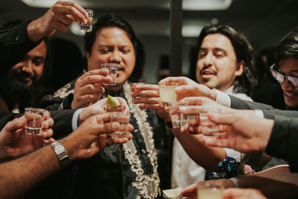 A group of friends raise their glasses together in a celebratory toast during a festive gathering.