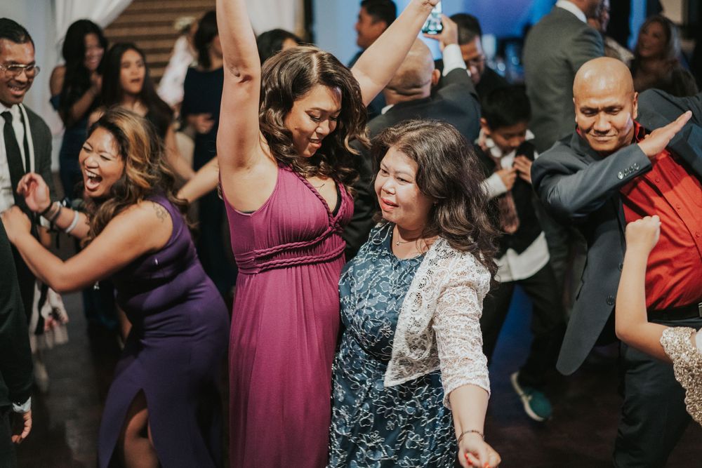 A lively group of partygoers dancing and having fun at a formal event wearing evening attire.