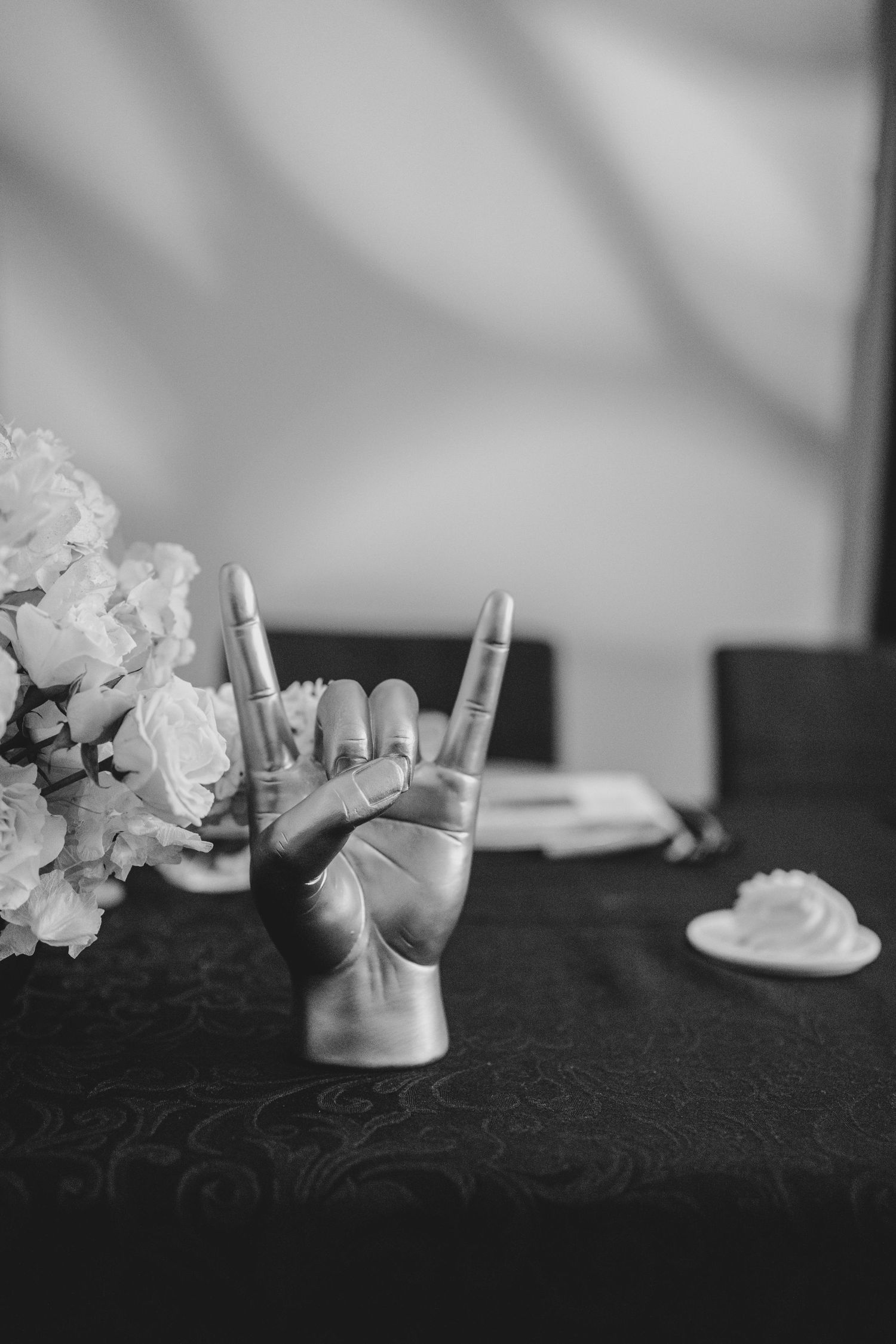 A black and white photo series showing crumpled paper tissues and feminine objects on a dark textured surface.