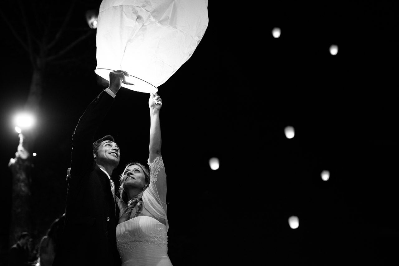 Black and white wedding celebration photos with floating lanterns at night.