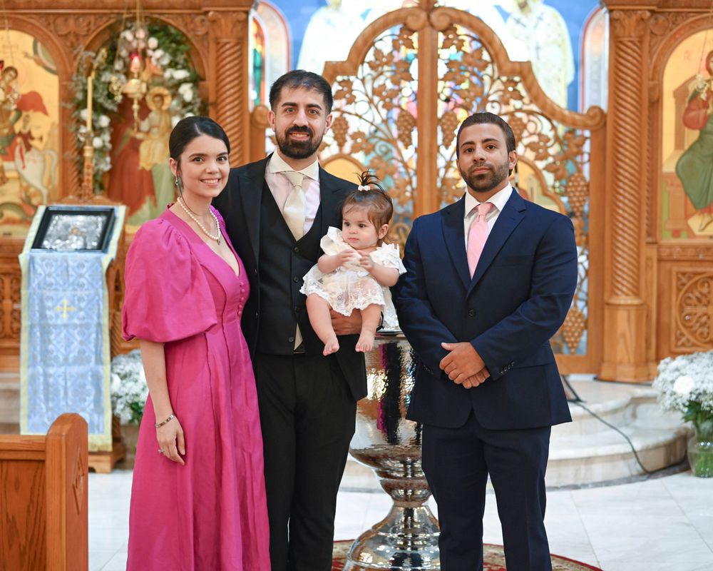 Family group photo in front of an ornate church altar with decorative icons.