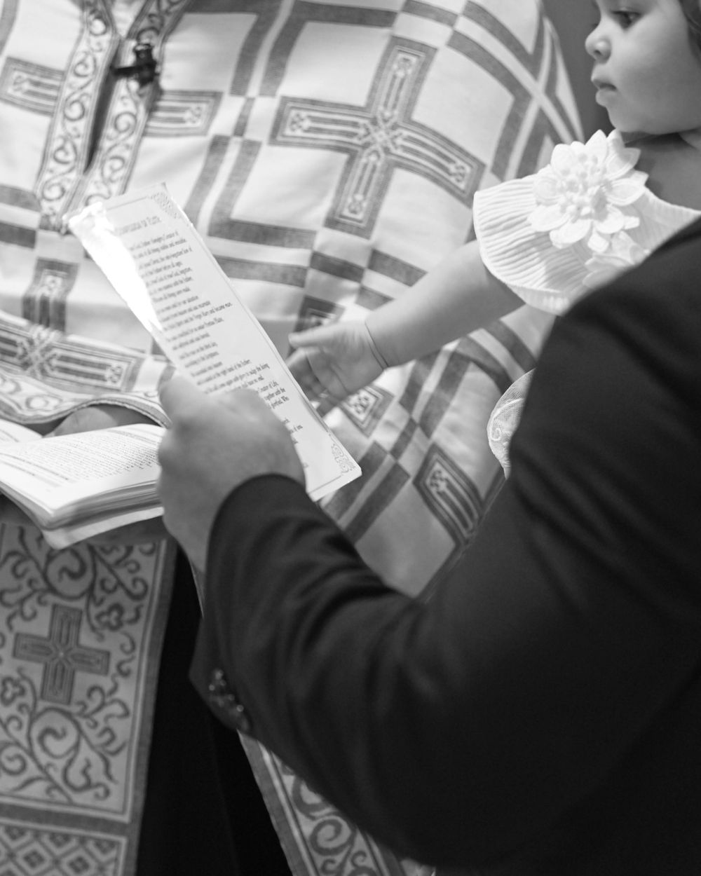 Person reading religious text against ornate church background with crosses.