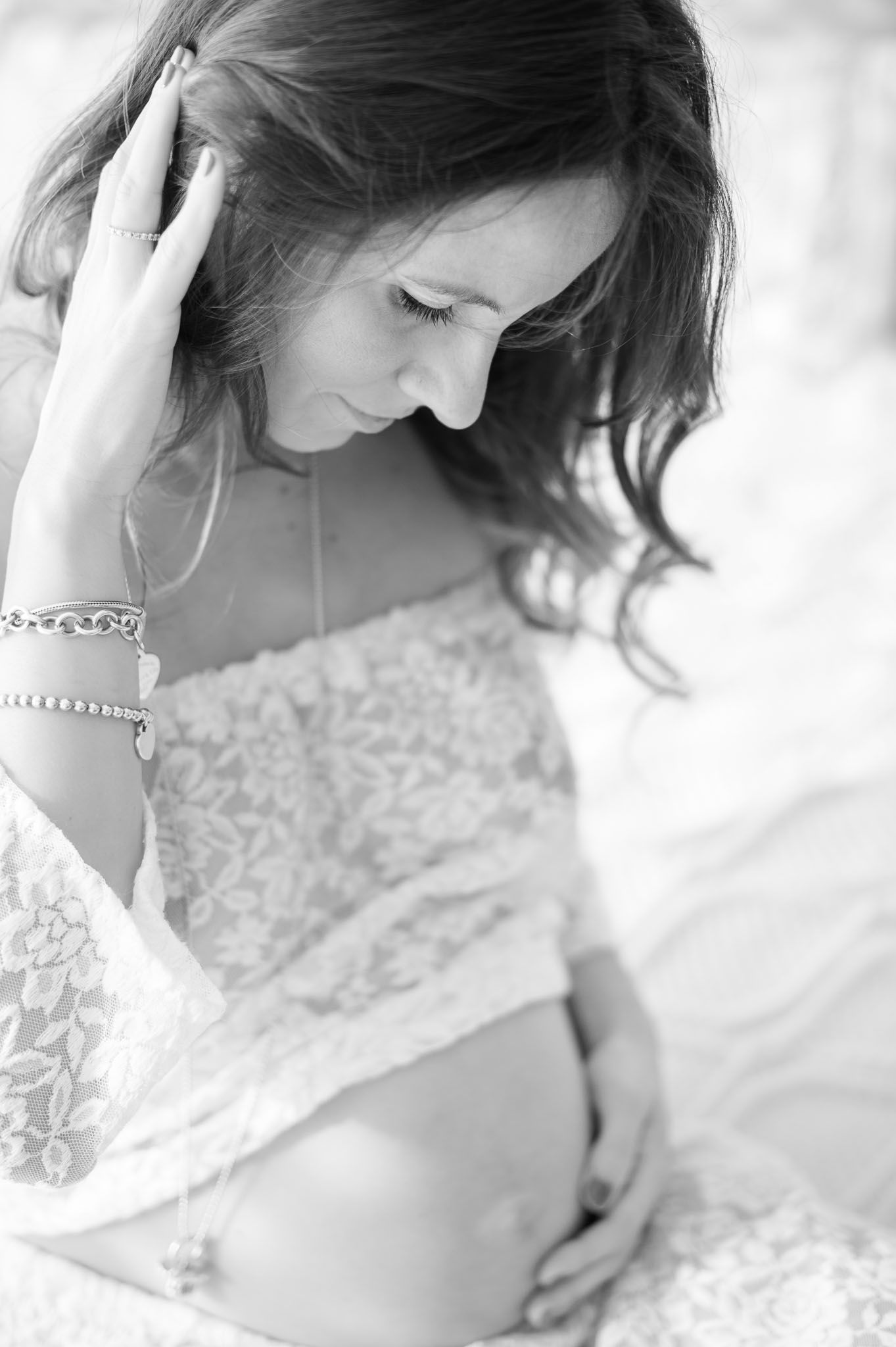 Black and white maternity portrait showing a tender moment with an expectant mother.