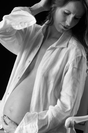 Intimate black and white maternity portrait in flowing white shirt.