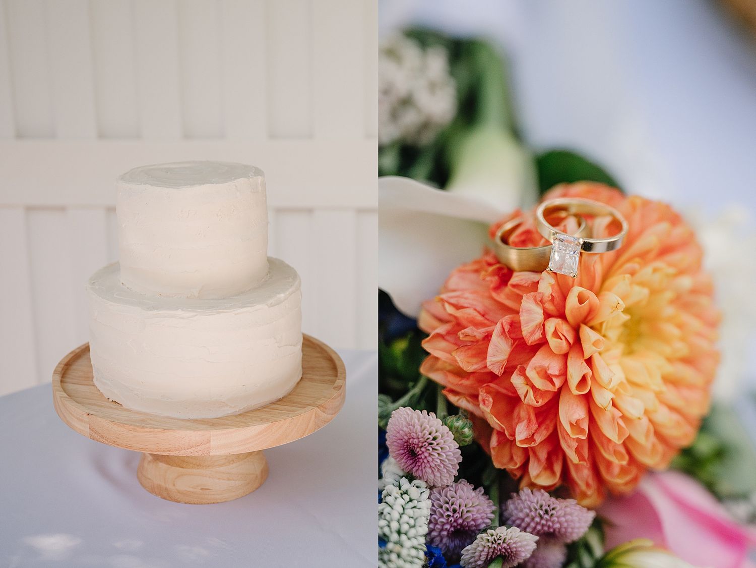 A simple two-tier white wedding cake next to a vibrant coral peach dahlia flower arrangement.