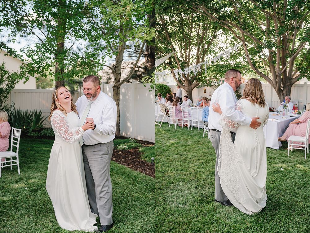 Guests dancing together on a green lawn at an outdoor wedding reception with white chairs and trees in the background.