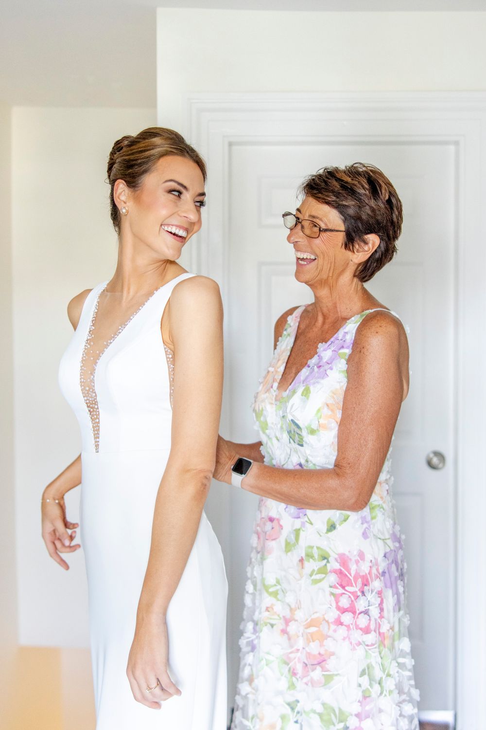 A tender moment shared during wedding preparations in a bright interior setting.