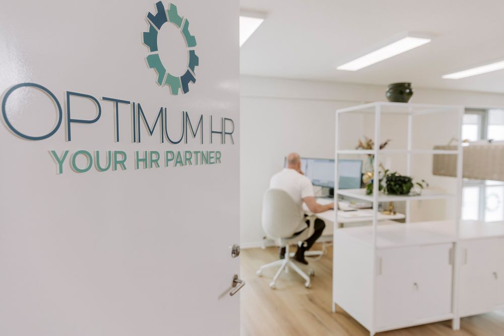 Rent hvidt kontorområde med Optimum HR Partner-logo vist på væggen. Branding fotograf Fyn.