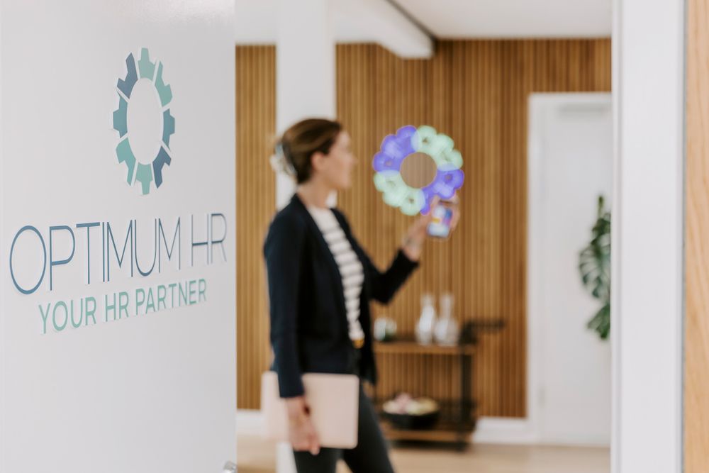 Moderne kontorinteriør med Optimum HR-logo og dekorative elementer på træbeklædt væg. Branding fotograf Fyn.