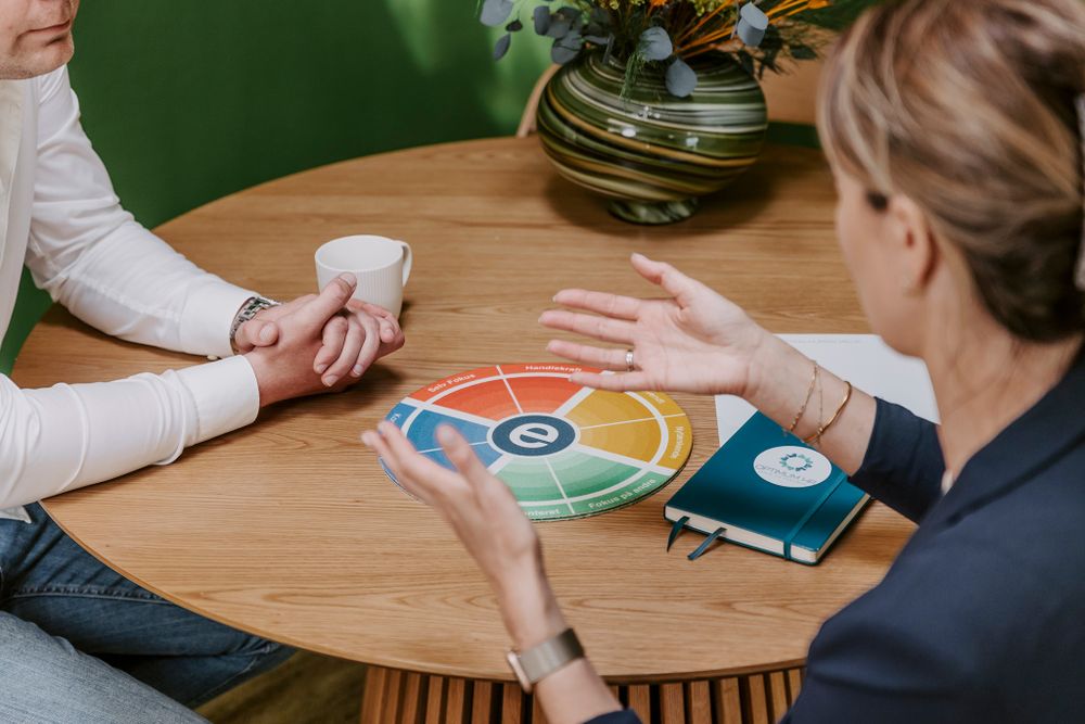 Forretningsmøde med farverigt cirkeldiagram på træbord, omgivet af dokumenter og diskussion. Branding fotograf Fyn.