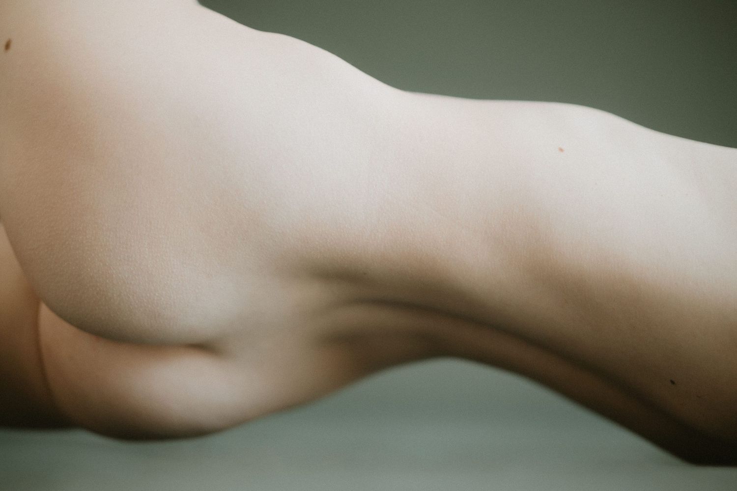 Close-up artistic black and white photo showing the contours and curves of an unclothed human torso.