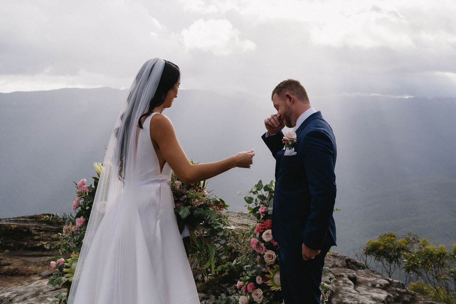 Emotional mountain-top wedding ceremony with scenic vista backdrop.