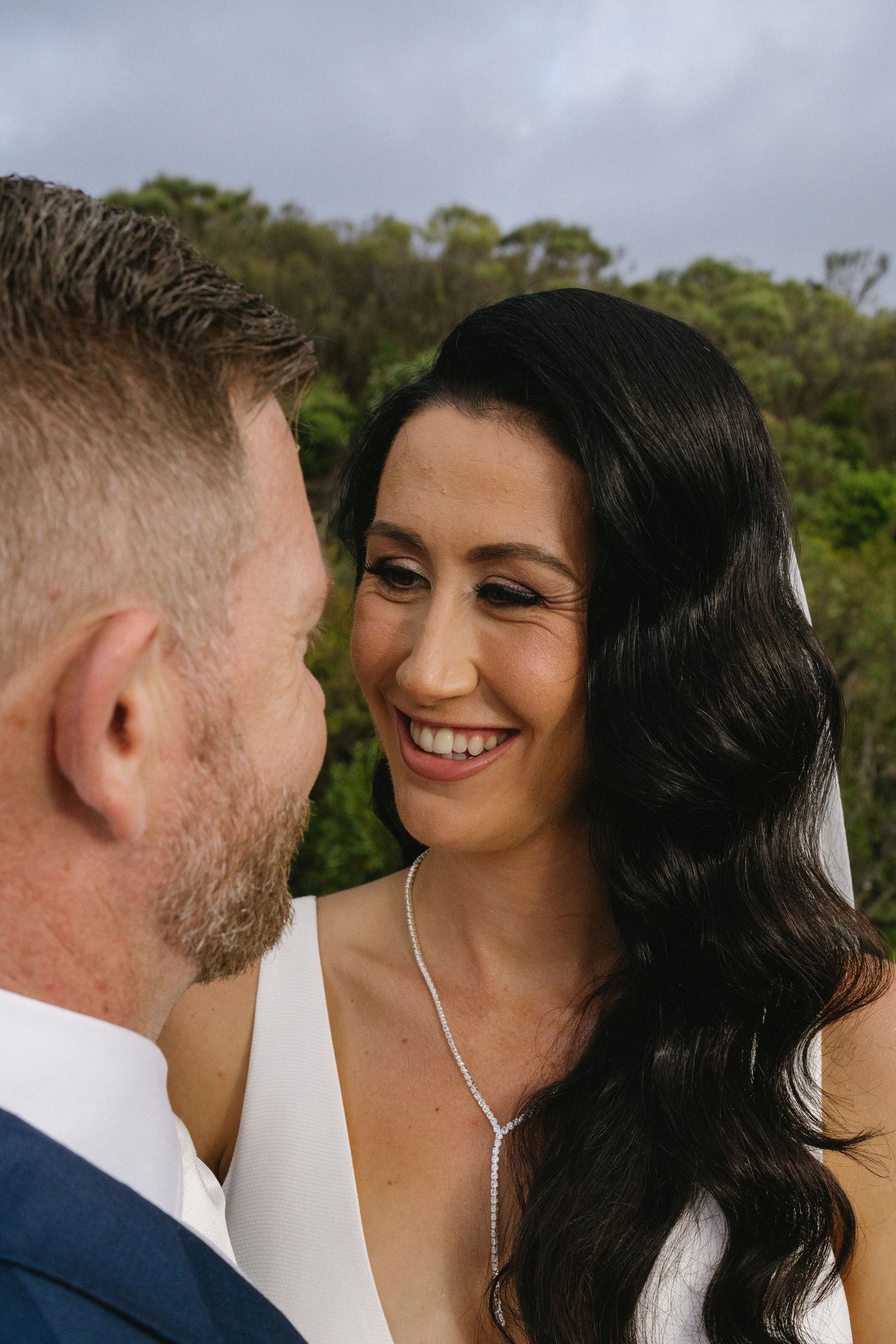 Close-up of romantic wedding couple sharing a tender moment outdoors.