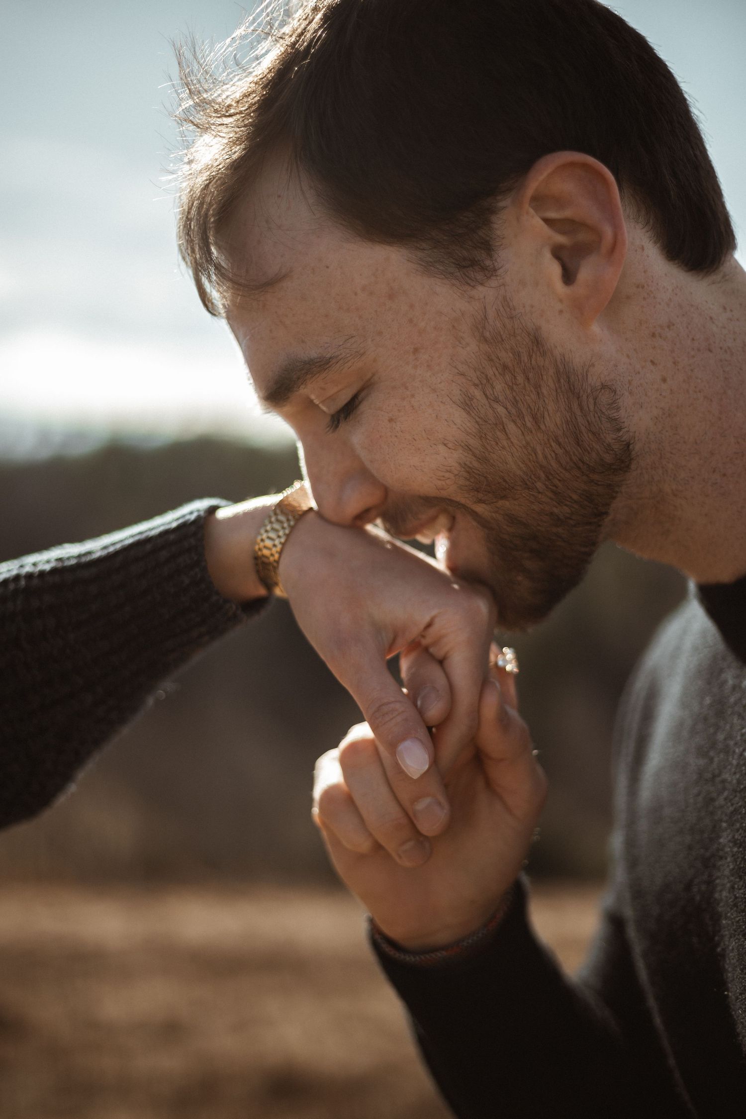 A tender moment captured in golden sunlight showing hands and gentle expression.