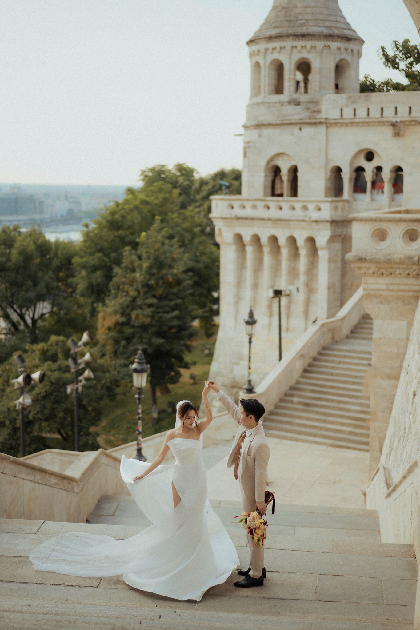 A couple in wedding attire dances on the steps of the historic Fisherman's Bastion in Budapest, Hungary.