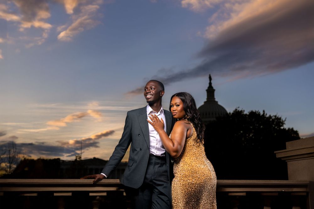 Couple poses against sunset sky in romantic outdoor portrait session.