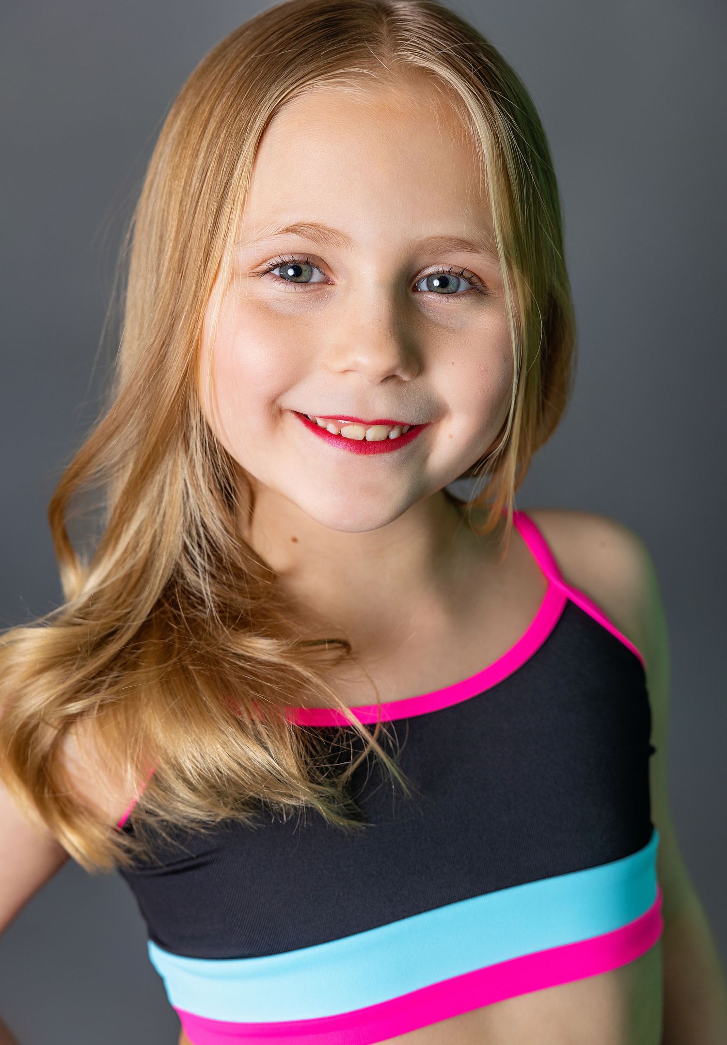 Studio portrait featuring colorful athletic wear and natural makeup.