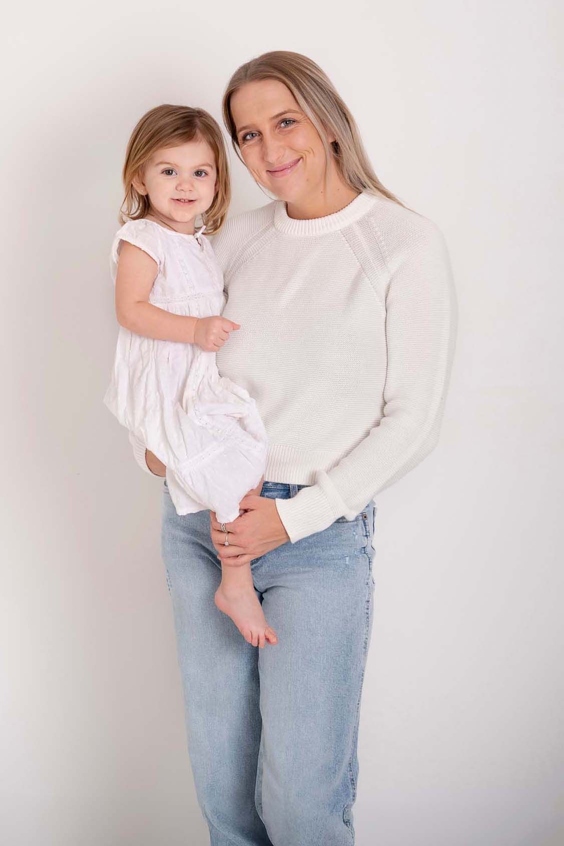 Mom and daughter posing together in a light & airy in-studio Mommy & Me photography session in Baltimore, Ontario. Professional portrait