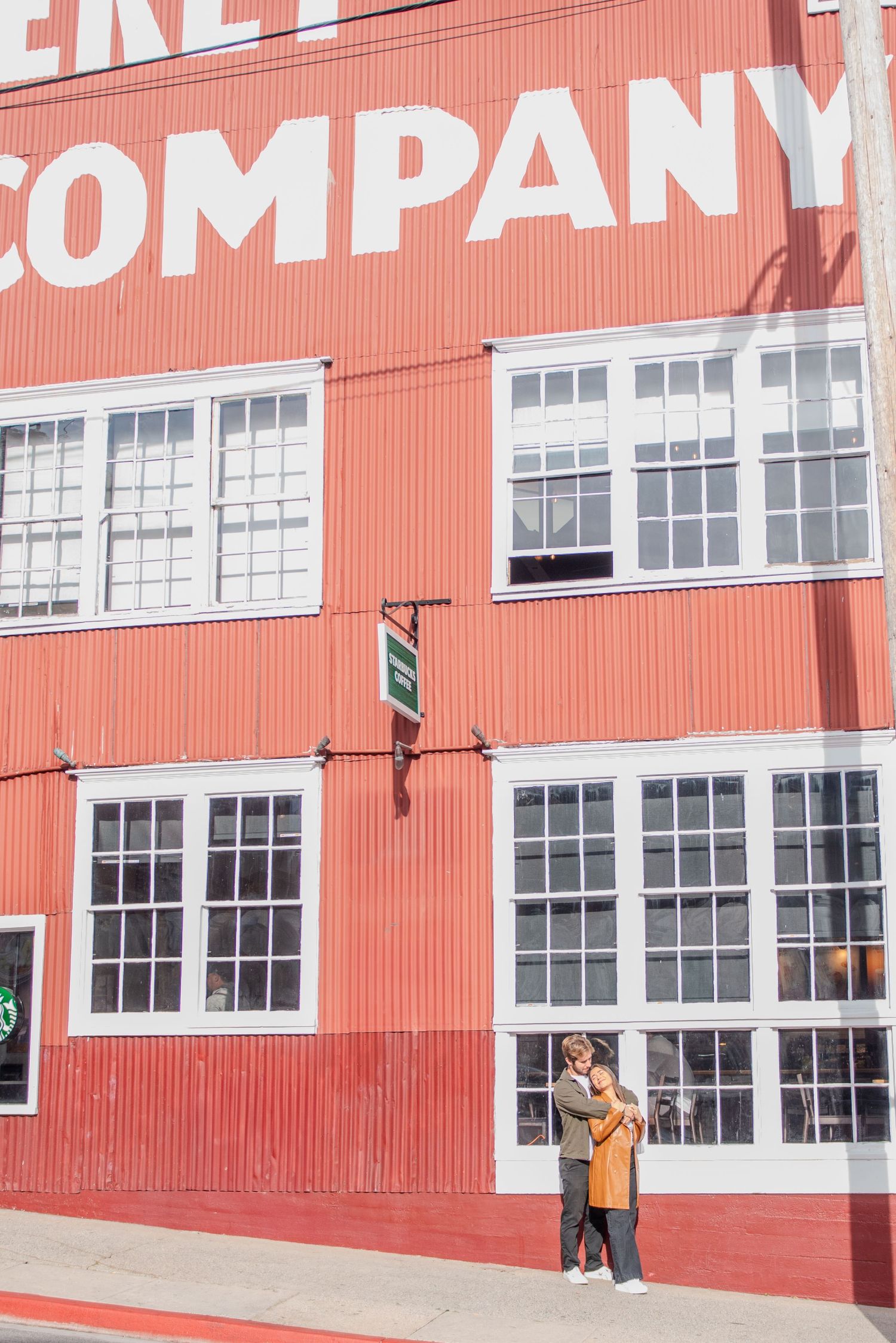Red industrial building with white windows and Company signage on the exterior.