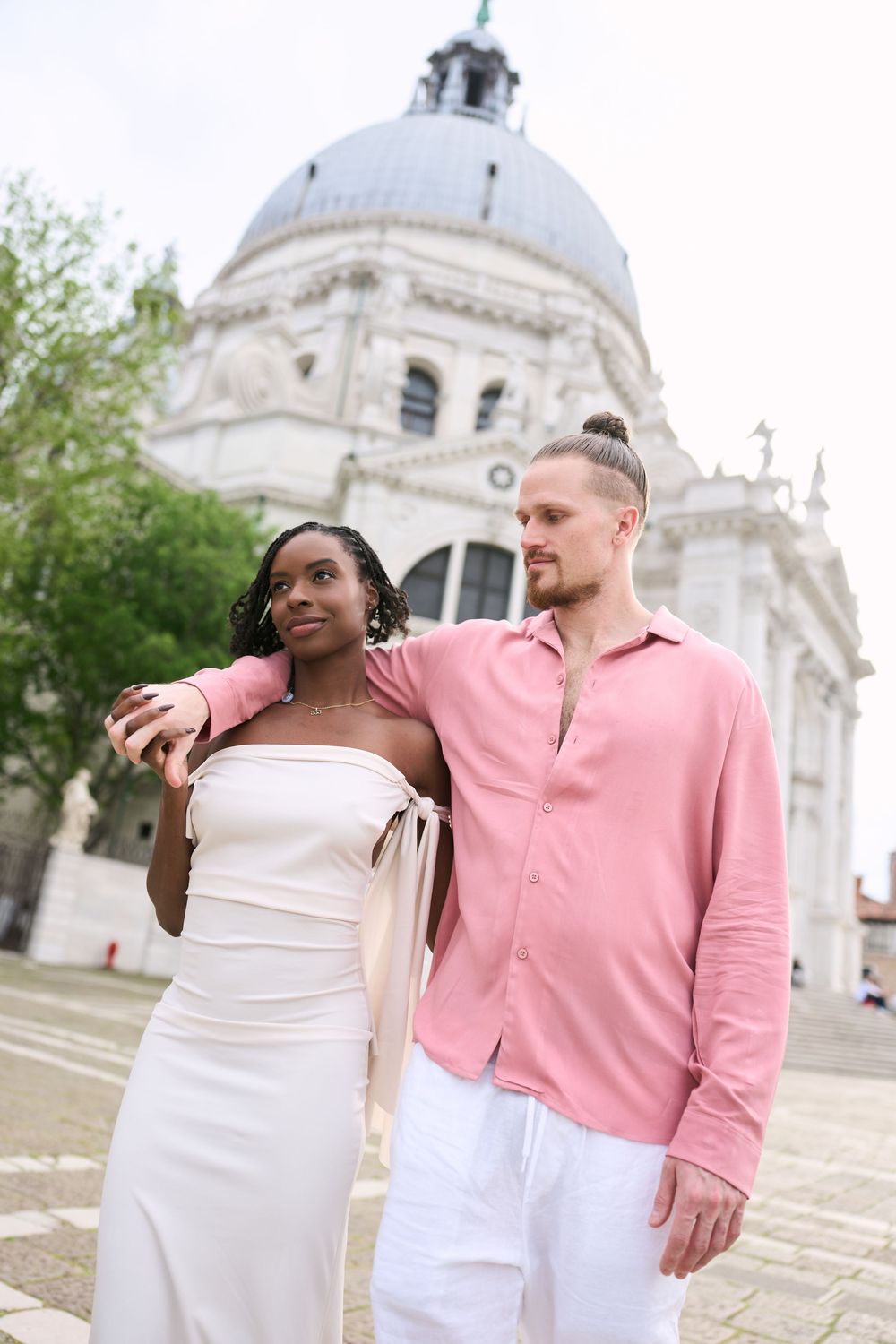 A couple poses in front of the Santa Maria della Salute basilica in Venice, Italy.