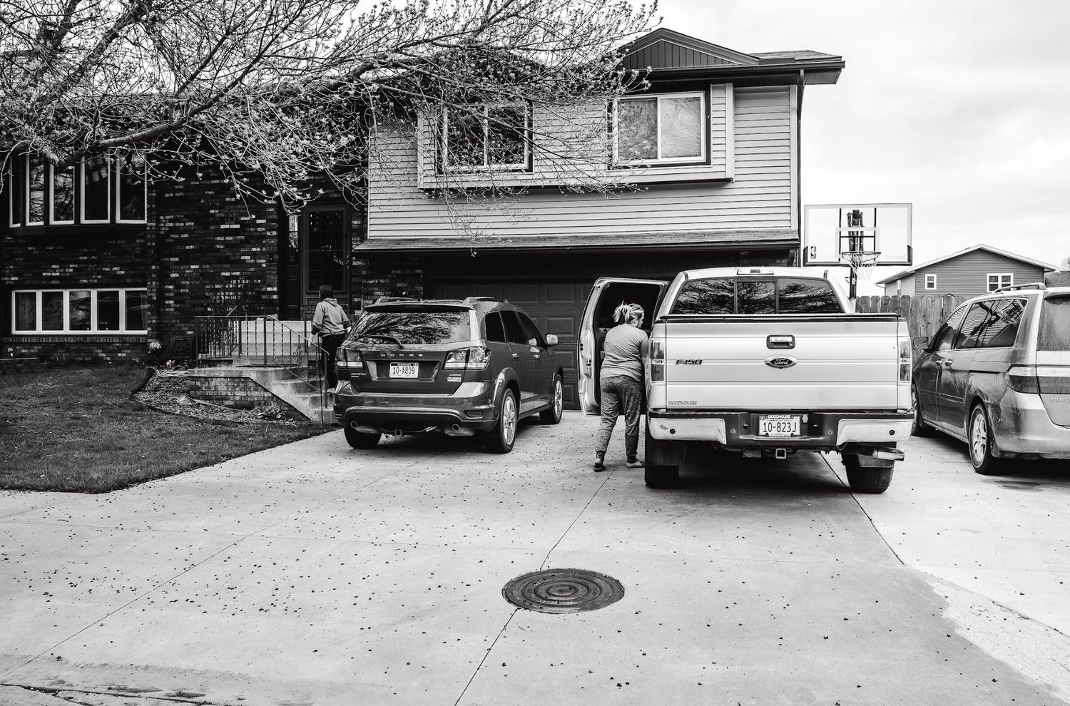 Residential driveway with multiple parked vehicles in suburban setting.