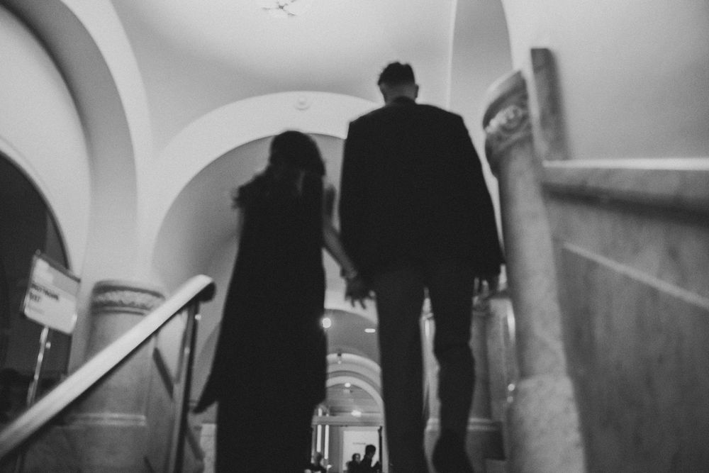 Silhouette of a couple holding hands walking up grand staircase in library of congress