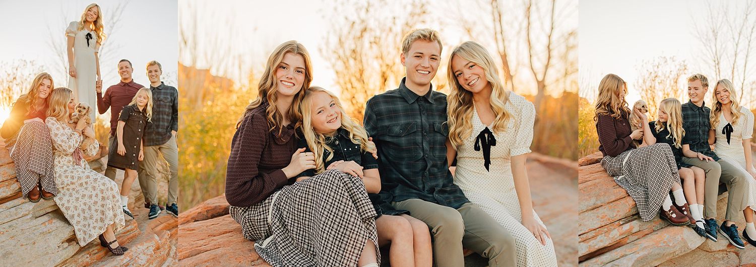 Family portrait session at golden hour with adults and children posing outdoors on wooden structure among autumn foliage.