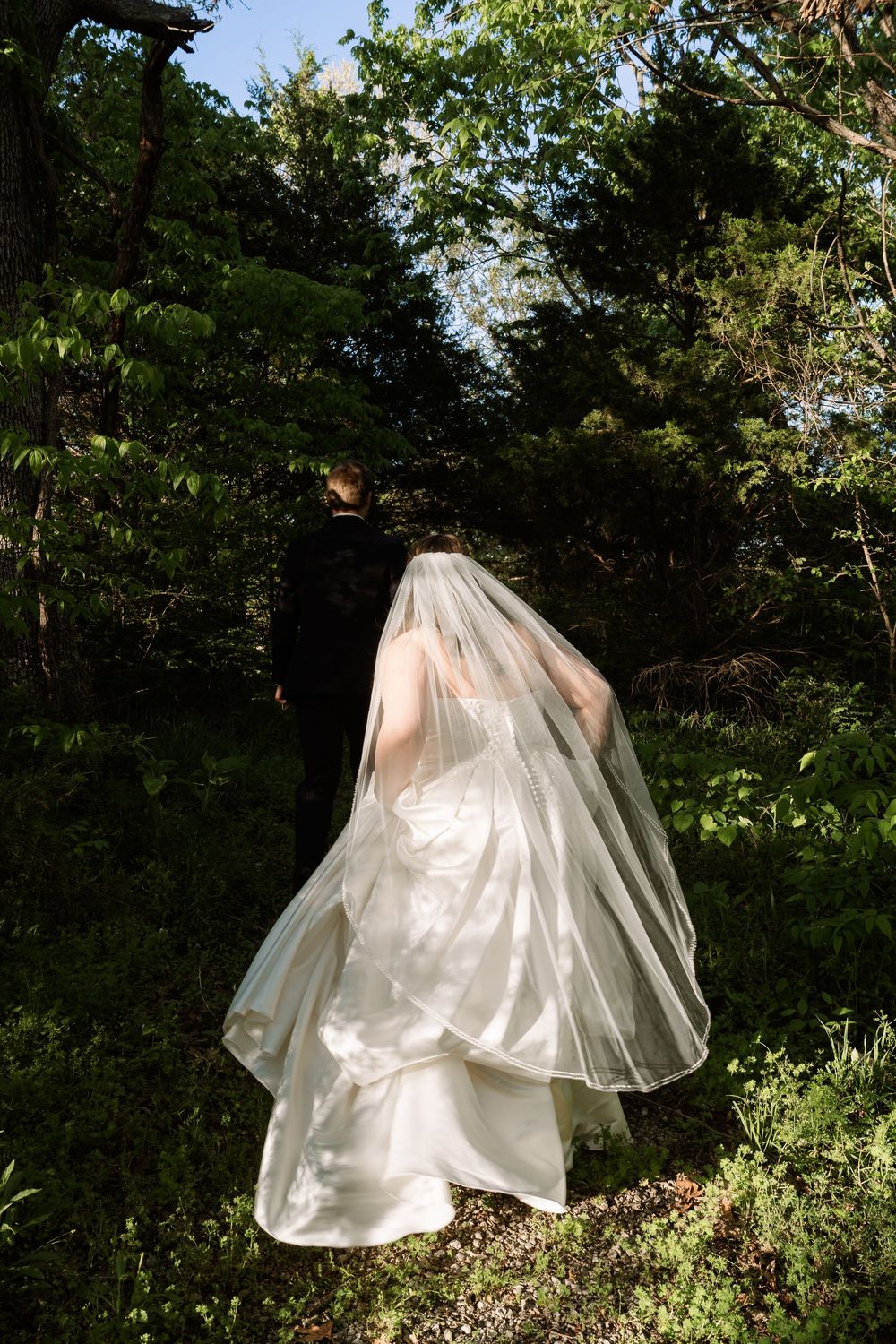 ©AnnaVonRiesenPhotography Bridal Portraits | Color image of a bride running into a green forest.