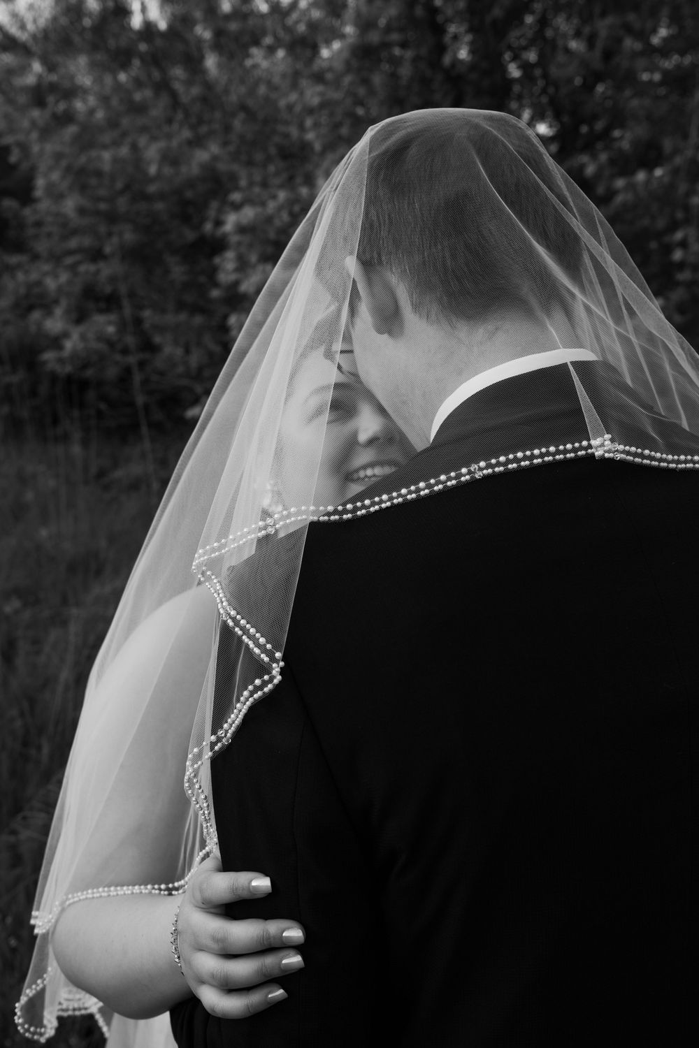 ©AnnaVonRiesenPhotography Bridal Portraits | B&W image of a bride smiling up at her groom.