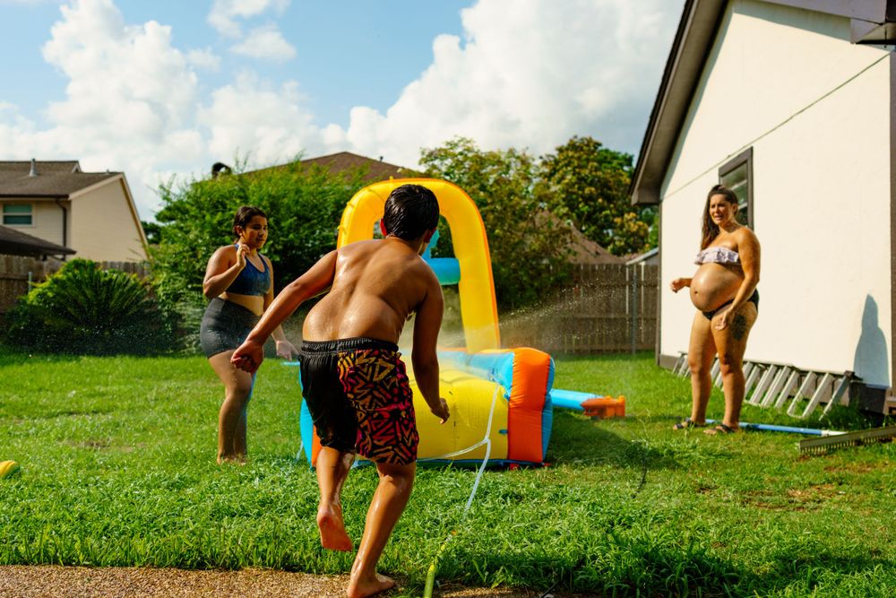 A series of outdoor shots showing an inflatable water slide and pool setup under blue skies.