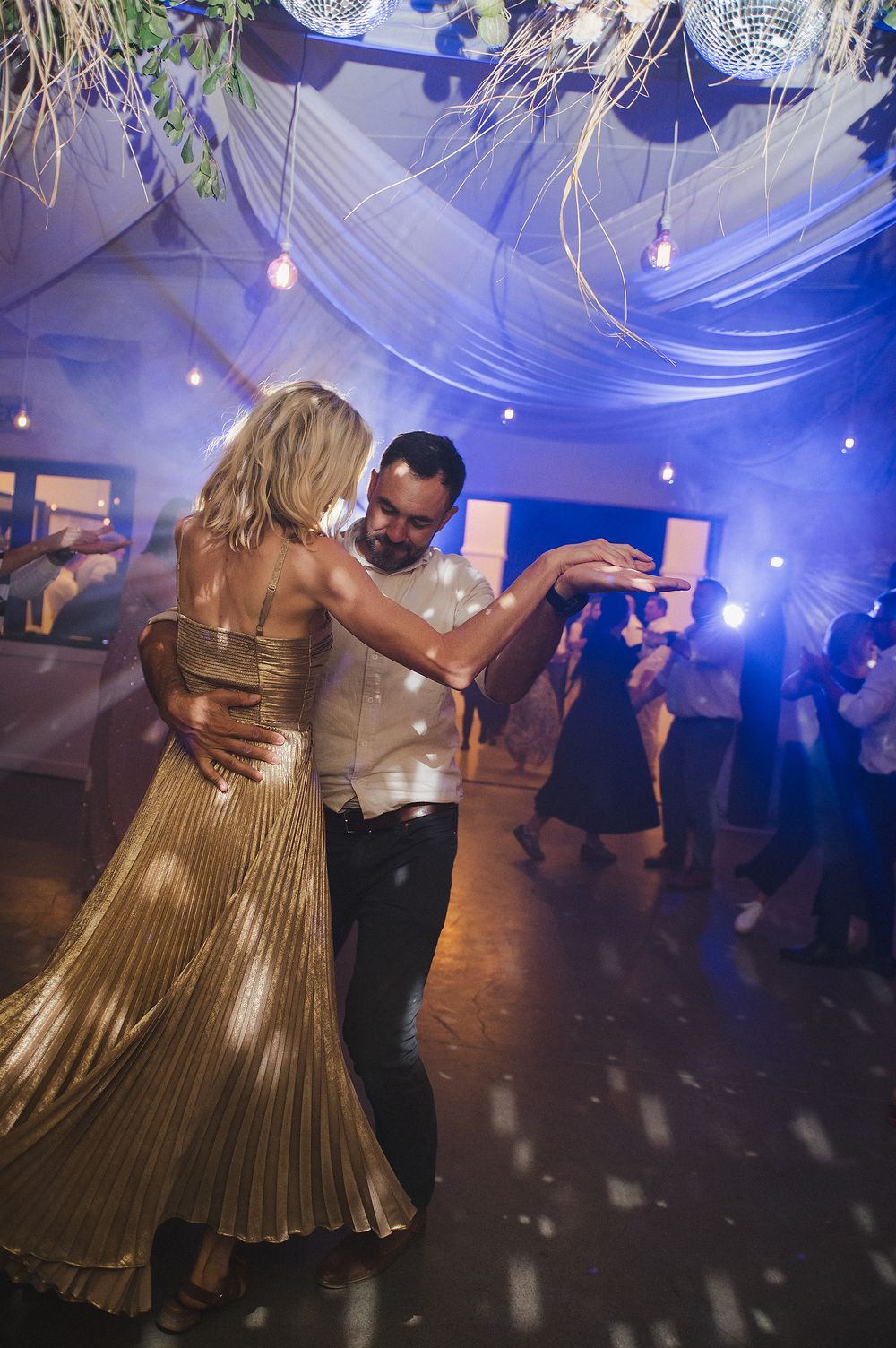 Guests celebrating together on the dance floor at romantic vineyard reception