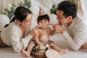 A series of tender family moments captured in white clothing as parents lovingly interact with their baby on a light backdrop一系列溫馨的家庭瞬間，身穿白色