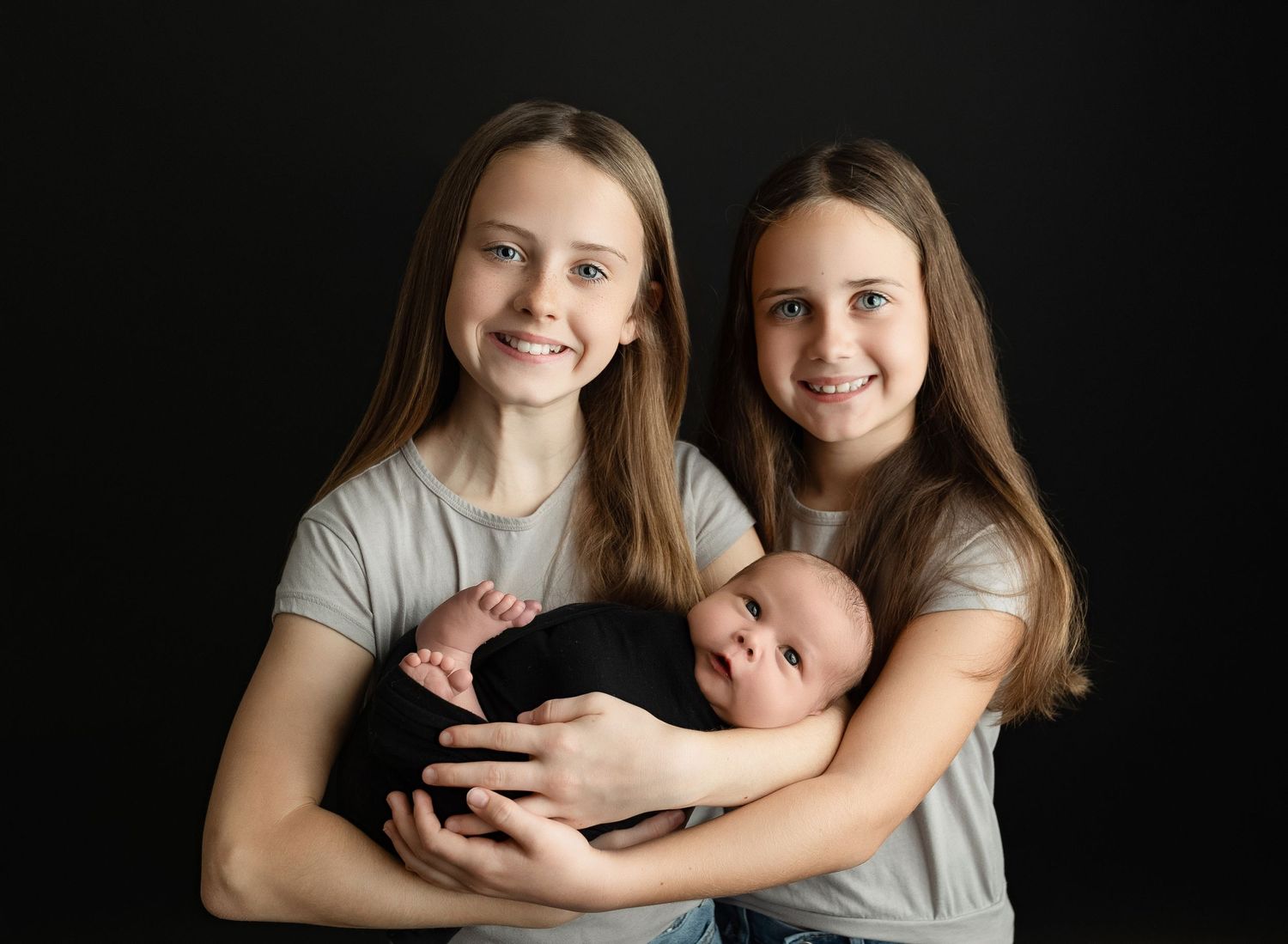 Big sisters holding newborn brother. Greenville SC newborn photographer, Easley, SC newborn photographer