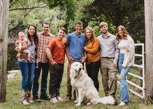 extended family with white dog by gate