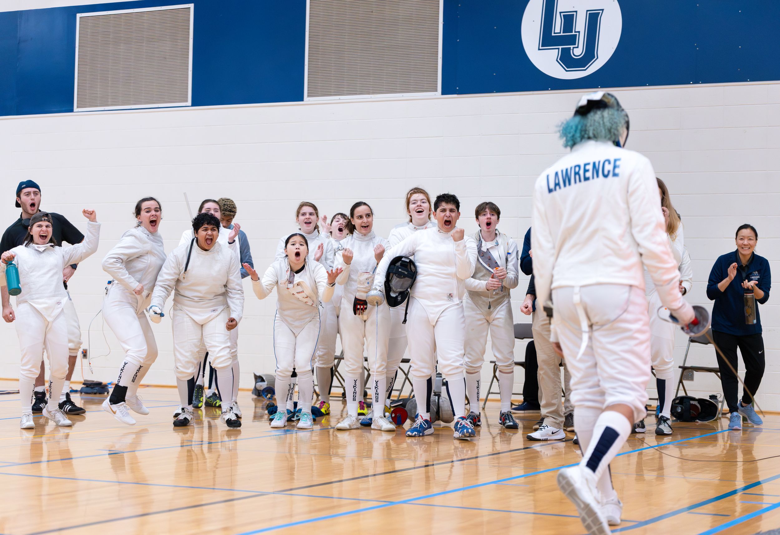 A fencing team celebrates a win.