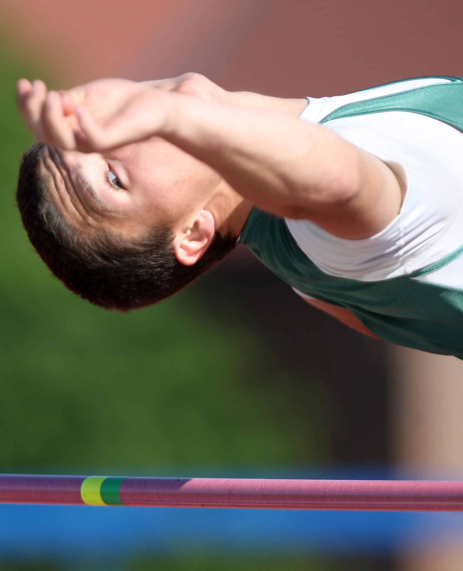 A high jumper clears a bar during a meet.
