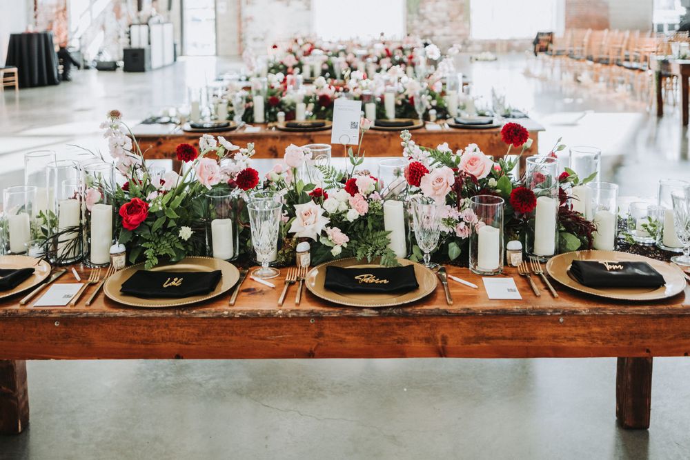 Elegant wedding table setting with floral centerpieces, gold chargers, and classic place settings.