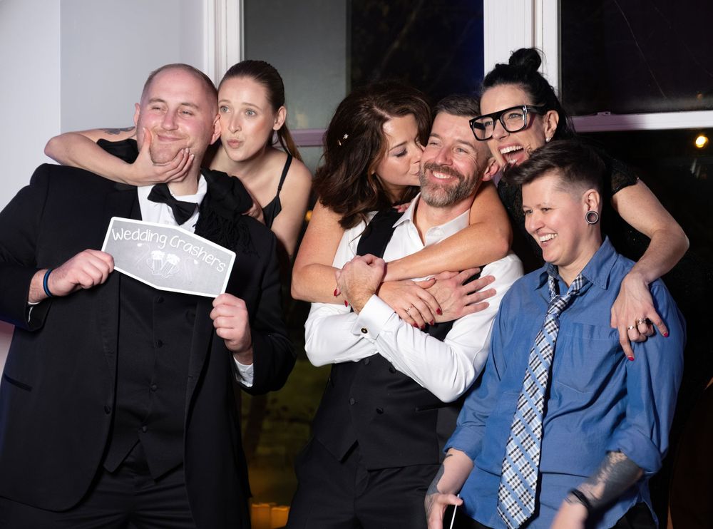 Group of wedding guests celebrating and posing together at reception party.