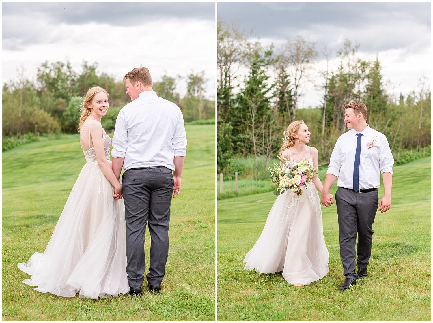 Bride in elegant gown and groom in suit hold hands while strolling through green meadow.