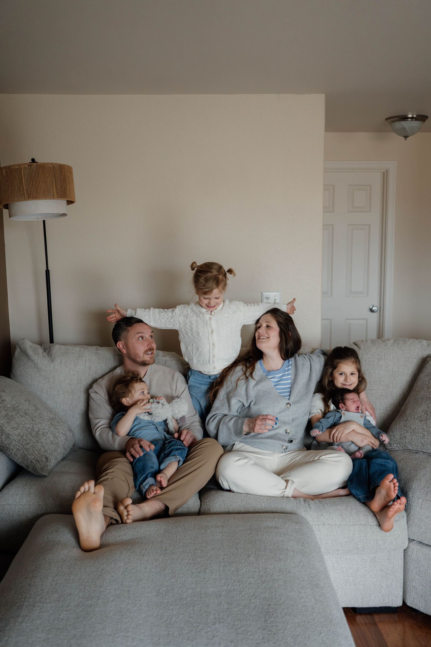 Family cuddling together during a relaxed in-home newborn and family photography session in Spokane, Washington.