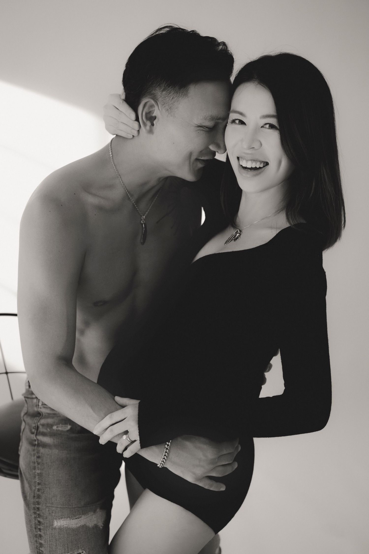 A romantic black and white photo series showing an intimate couple embracing in casual attire一組浪漫的黑白照片，展現了一對穿著休閒裝的親密情侶擁抱在一起的畫面。