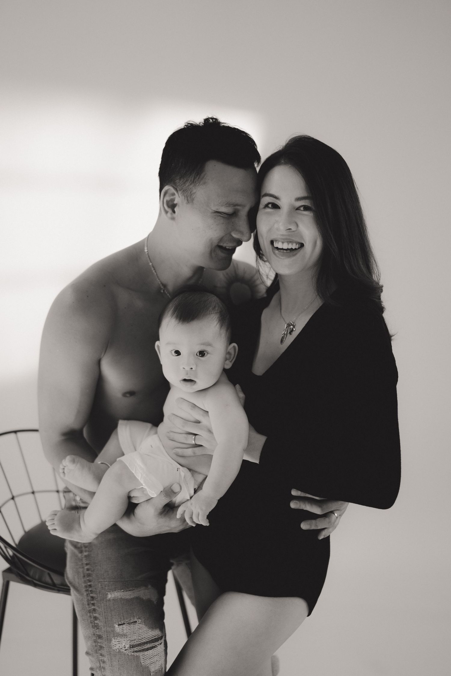 Black and white photo series showing intimate family moments with a baby in monochromatic tones.一組黑白照片，以單色調展現了一家人與嬰兒的溫馨家庭時光。