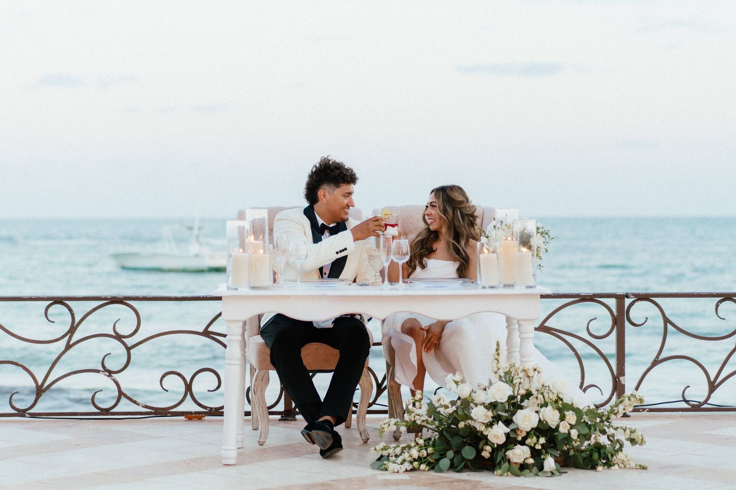 Newlyweds sharing their first toast at Villa La Joya reception with ocean views in Riviera Maya.