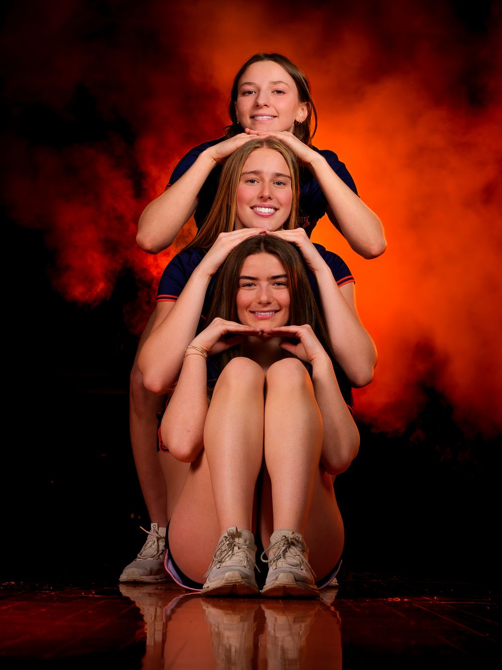 Hershey Lacrosse seniors pose together with orange fog background, Media Day by Deanna Fox, SportsFox Photography based in Hershey PA