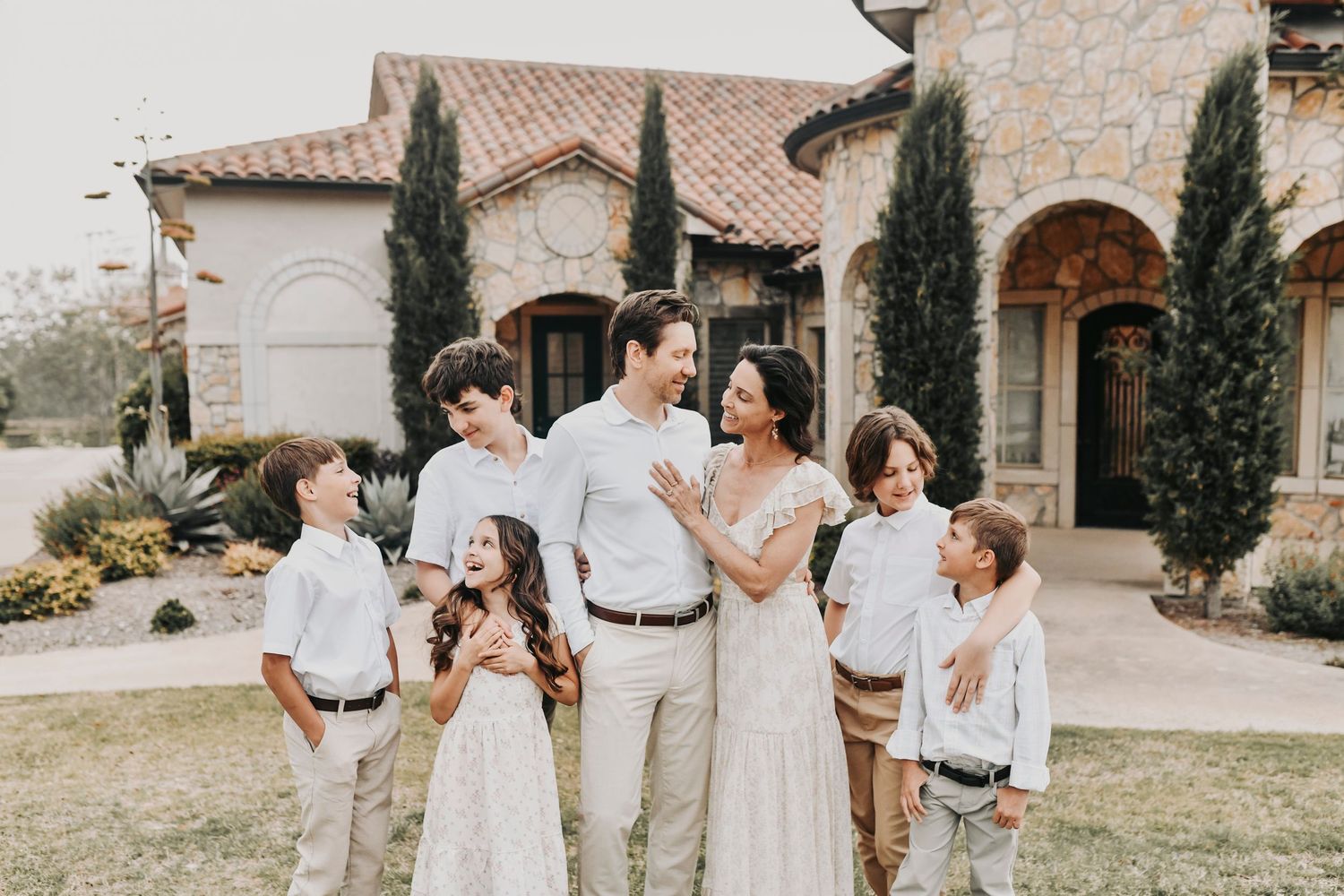 siblings and happy parents smile at adriatica village for their family photos