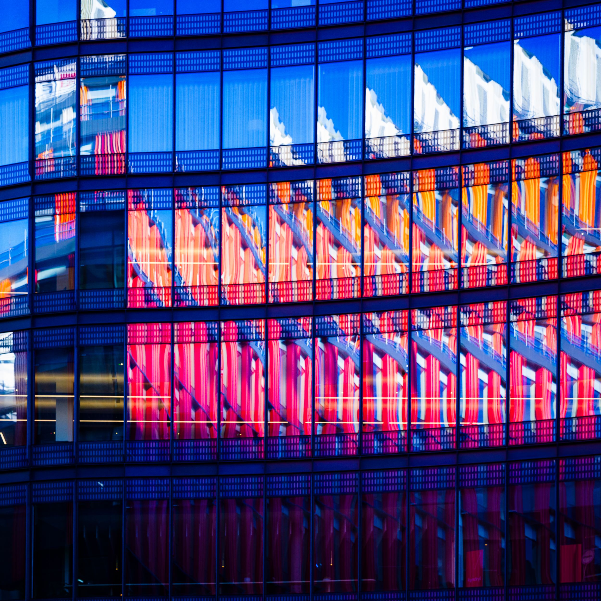 Colourful glass building facade with vibrant reflections, architecture photography