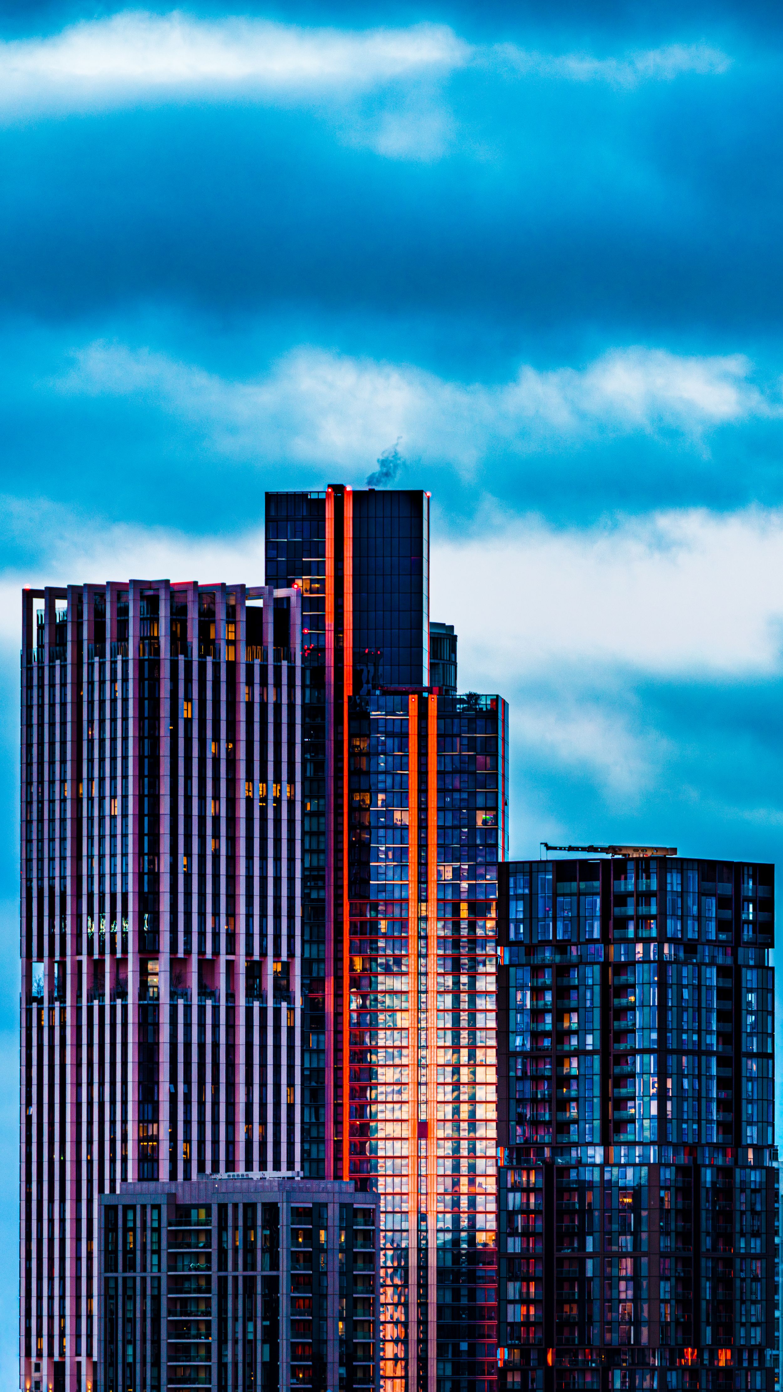 Architectural photo of colourful skyscrapers against a moody cloudy sky