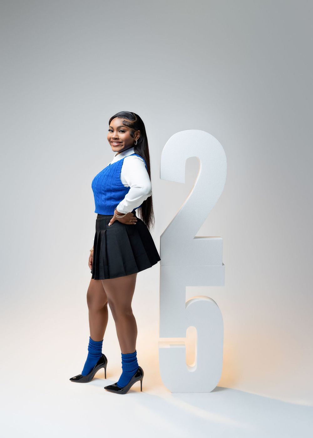 Creative fashion photo series showing white block numbers 2024 with model in black and blue activewear outfit.